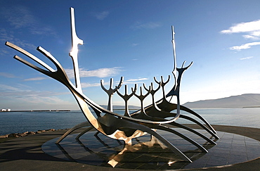 The midnight sun lights up the giant steel boat sculpture that stands on the water's edge at Reykjavik, Iceland, Polar Regions