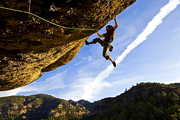 A climber tackles an exceptionally difficult, F8c graded, route on a big overhang at the cliffs of Margalef, underneath Montsant, near Lleida and Tarragona, Catalunya, Spain, Europe