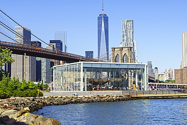 Jane's Carousel in Brooklyn Bridge Park with Brooklyn Bridge and Lower Manhattan skyscrapers including One World Trade Center beyond, New York City, New York, United States of America, North America