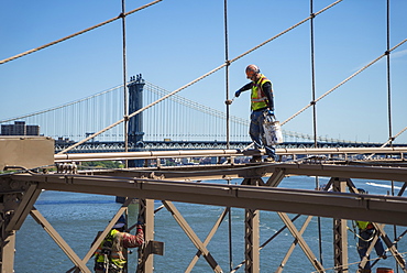 Workmen repainting beams and cables on Brooklyn Bridge, New York City, New York, United States of America, North America