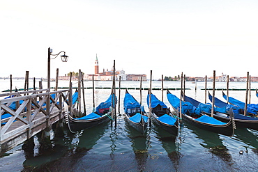 Gondolas moored on the Lagoon, San Giorgio Maggiore beyond, Riva degli Schiavoni, Venice, UNESCO World Heritage Site, Veneto, Italy, Europe