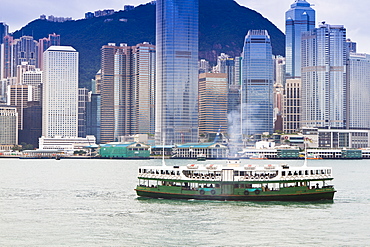 Star ferry crosses Victoria Harbour with Hong Kong Island skyline behind, Hong Kong, China, Asia