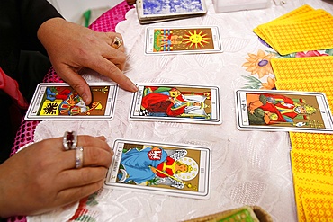 Fortuneteller laying cards on the table during a divination, Paris, France, Europe