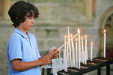 Boy lighting a church candle