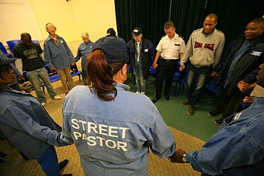 Street Pastors praying with a policeman in North London, London, England, United Kingdom, Europe