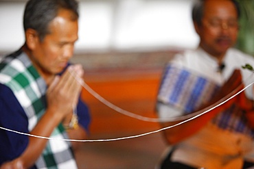 Lao Buddhist ceremony with cotton bracelets, Paris, France, Europe