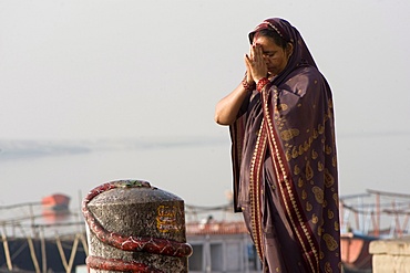 Woman praying in front of a lingam, Varanasi, Uttar Pradesh, India, Asia