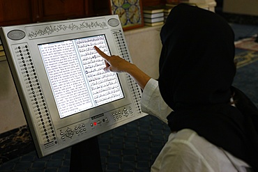 Woman reading an Arabic and English electronic version of The Holy Koran, Dubai, United Arab Emirates, Middle East