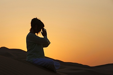 Sunset meditation in the desert, Abu Dhabi, United Arab Emirates, Middle East