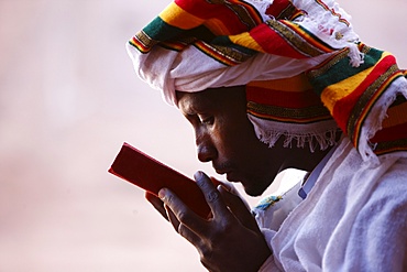 Faithful kissing a Bible outside a church in Lalibela, Ethiopia, Africa