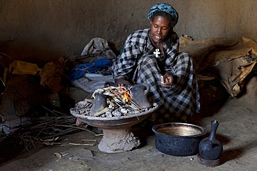 Ethiopian woman setting fire to boil the water for coffee for traditional ceremony, Debre Libanos, Shoa, Ethiopia, Africa