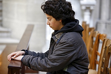 Teenager praying in Notre Dame de Bayeux cathedral, Bayeux, Normandy, France, Europe