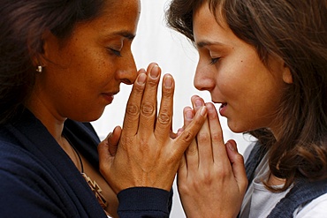 Mother and daughter praying at home, Paris, France, Europe