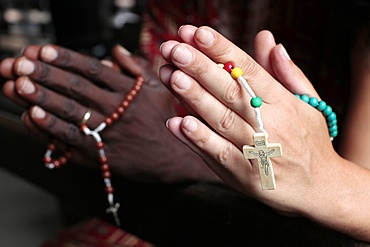 Man and woman praying together with rosaries in a church, Cotonou, Benin, West Africa, Africa