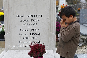 Girl putting flowers on her grandmother's grave, Our, Doubs, France, Europe