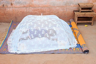 Baby sleeping under a mosquito net, Lome, Togo, West Africa, Africa