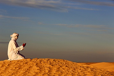 Bedouin praying in the Sahara, Douz, Kebili, Tunisia, North Africa, Africa