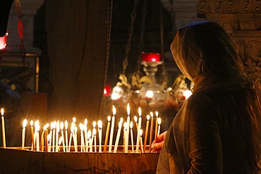 Pilgrim lighting candles in the Holy Sepulchre Church, Jerusalem, Israel, Middle East