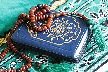 Quran and Islamic prayer beads on a prayer mat, Paris, France, Europe