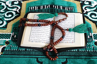 Quran and Islamic prayer beads on a prayer mat, Paris, France, Europe