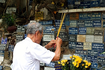 Man praying in copy of the Grotto of Massabielle, St. Philip Church (Huyen Sy Church), Ho Chi Minh City, Vietnam, Indochina, Southeast Asia, Asia