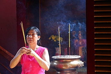 Buddhist worshipper with incense sticks, Khanh Van Nam Vien Taoist pagoda, Ho Chi Minh City, Vietnam, Indochina, Southeast Asia, Asia