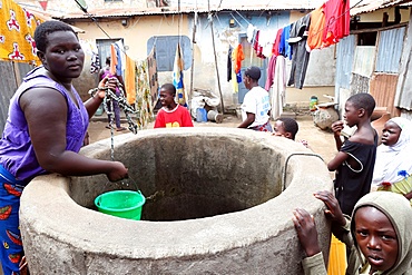 A woman draws water from a well, Lome, Togo, West Africa, Africa