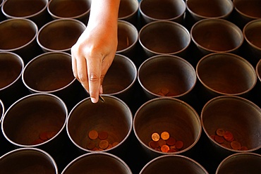 Child offering coins in Wat Suandok, Chiang Mai, Thailand, Southeast Asia, Asia