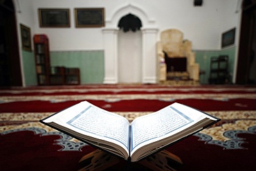 An open Holy Quran on wood stand with mihrab in background, Hanoi, Vietnam, Indochina, Southeast Asia, Asia