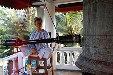 Buddhist worshipper rings bell, Phuoc Thanh Buddhist pagoda, Cai Be, Vietnam, Indochina, Southeast Asia, Asia