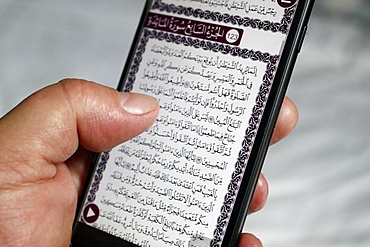 Man reading an electronic Quran on a smartphone, Vietnam, Indochina, Southeast Asia, Asia