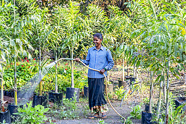 Gardener watering one of the gardens at Goverdan ecovillage, Maharashtra, India, Asia