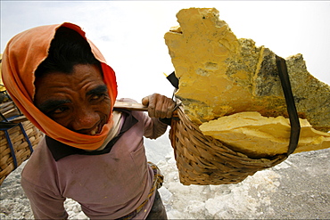 Sulphur worker carrying heavy baskets of sulphur, by the crater lake of the Kawa Ijan volcano, Baluran National Park, Java, Indonesia, Southeast Asia, Asia