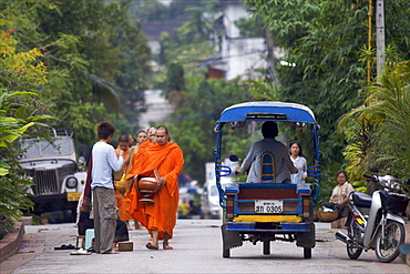 Monks during the dawn procession for food in the streets in Luang Prabang, Laos, Indochina, Southeast Asia, Asia