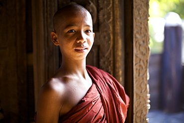 A young monk at the Shwenandaw Kyanung wooden temple, in Mandalay, Myanmar (Burma), Asia