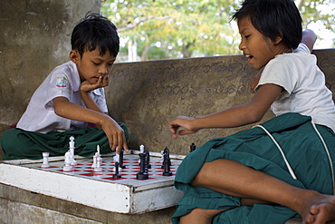 Children playing chess on the stairs of the great temple of Mandalay, Myanmar (Burma), Asia