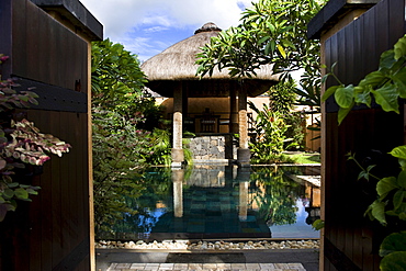 Outdoor swimming pool within a walled garden with thatched loggia, Baie aux Tortues, Pointe aux Pimentes, Mauritius, Africa