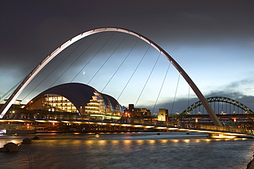 Exterior at dusk of the Sage Gateshead, architect Foster and Partners, seen through Millennium Bridge, Gateshead, Tyne and Wear, England, United Kingdom, Europe