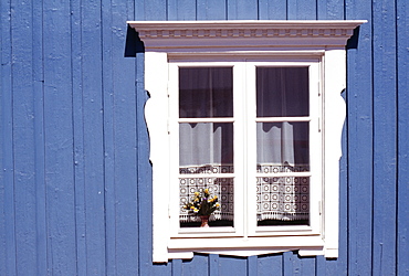 White window on blue wood clad house, traditional Swedish village style with crochet work curtain, Vimmerby, Smaland, Sweden, Scandinavia, Europe