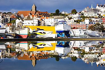 St. Peter Port and harbour side boats stored on dry dock reflected in a model boat pond in Guernsey, Channel Islands, United Kingdom, Europe