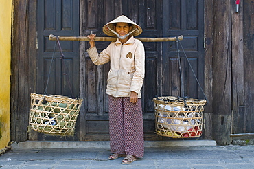 Woman vendor carrying food to the market, Hoi An, Vietnam, Indochina, Southeast Asia, Asia