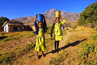 Young girls going to the water well, Andringitra National Park, Madagascar, Africa