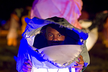 Young boy looking through his giant mask at the Festival of the Creoles, Fete de Creoles, Mahe, Seychelles, Africa