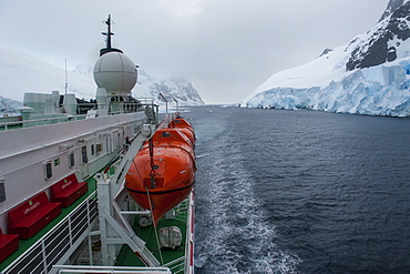 Cruise ship slowly passing through the Lemaire Channel, Antarctica, Polar Regions 