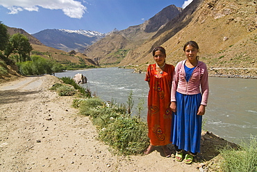 Smiling women posing by river, Wakhan Valley, The Pamirs, Tajikistan, Central Asia, Asia