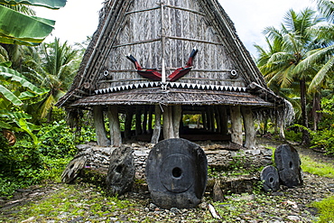 Traditional house with stone money in front, Island of Yap, Federated States of Micronesia, Caroline Islands, Pacific 