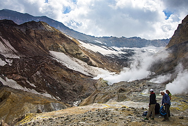 Tourists standing by smoking fumaroles on Mutnovsky volcano, Kamchatka, Russia, Eurasia 