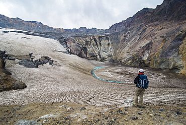 Tourist standing on a glacierfield on Mutnovsky volcano, Kamchatka, Russia, Eurasia 