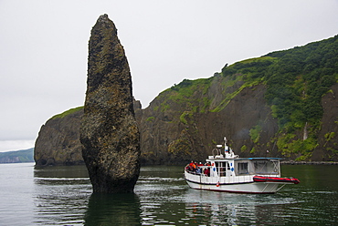 Little tourist boat ships beside a large monolith in the Avacha Bay near Petropavlovsk-Kamchatsky, Kamchatka, Russia, Eurasia