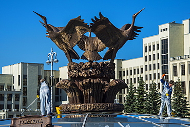 Woman cleaning a giant bird statue on top of a glass cupola on Nezalezhnasti Independence square, Minsk,Belarus, Europe 